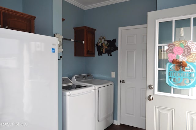 washroom with washer and clothes dryer, cabinets, and crown molding