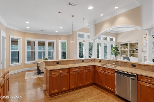 kitchen with visible vents, dishwasher, brown cabinets, ornate columns, and a sink