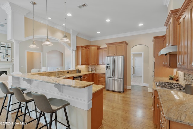 kitchen with decorative light fixtures, stainless steel appliances, visible vents, light stone countertops, and a peninsula