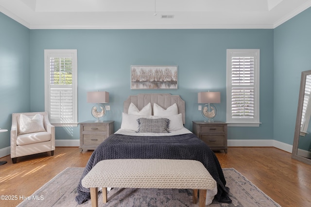 bedroom with light wood-type flooring, baseboards, and crown molding