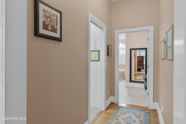 hall featuring light wood finished floors and baseboards