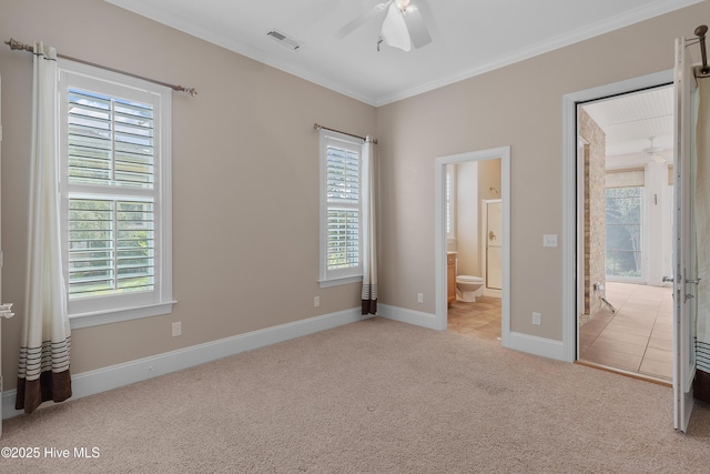 unfurnished bedroom with light carpet, multiple windows, visible vents, and ensuite bathroom