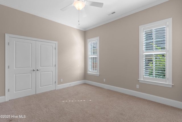 unfurnished bedroom with light carpet, baseboards, visible vents, and crown molding