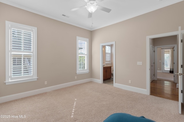 unfurnished bedroom with light carpet, visible vents, baseboards, ensuite bathroom, and crown molding