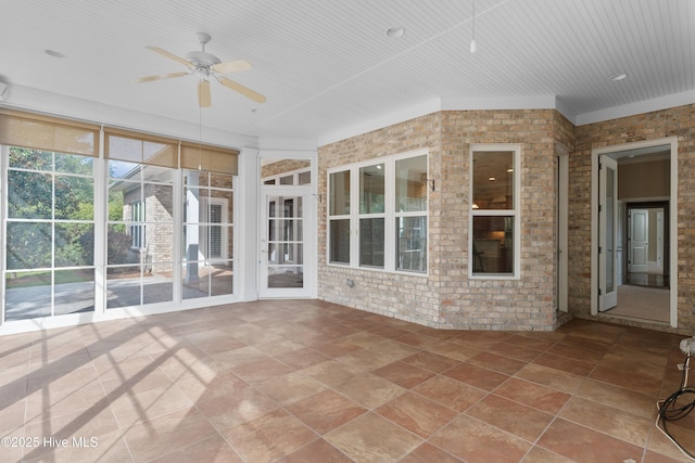 unfurnished sunroom with ceiling fan