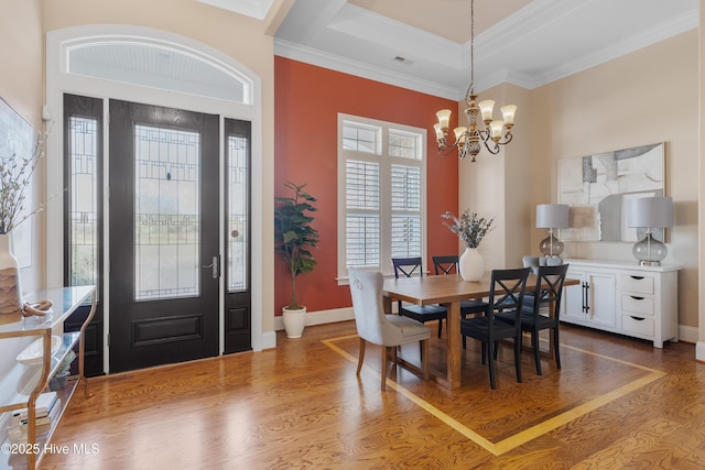 dining area with crown molding, baseboards, wood finished floors, and a notable chandelier