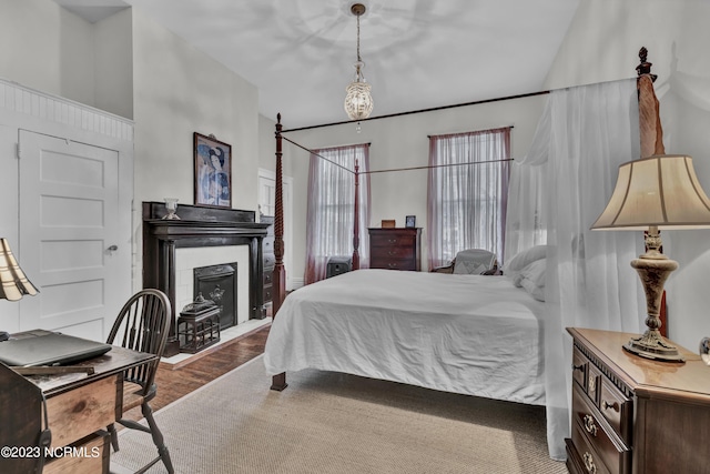 bedroom featuring a fireplace and wood finished floors