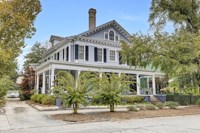 view of front of home with covered porch and a chimney