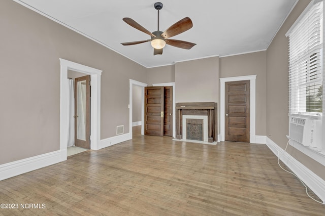 unfurnished living room with cooling unit, crown molding, ceiling fan, and light wood-type flooring