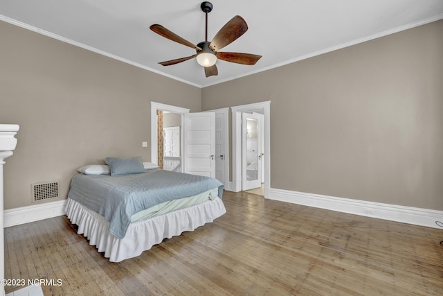 bedroom featuring wood-type flooring, ornamental molding, ensuite bathroom, and ceiling fan