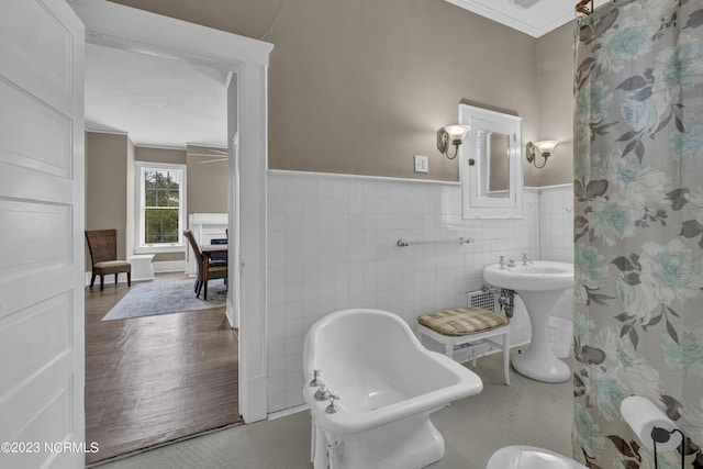 bathroom featuring crown molding, toilet, sink, and tile walls