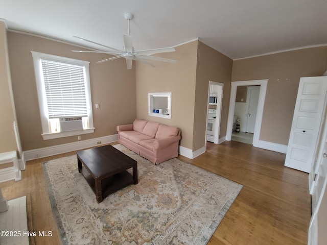 living room with cooling unit, wood-type flooring, ornamental molding, and ceiling fan