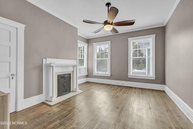 unfurnished living room with ceiling fan, ornamental molding, and light wood-type flooring