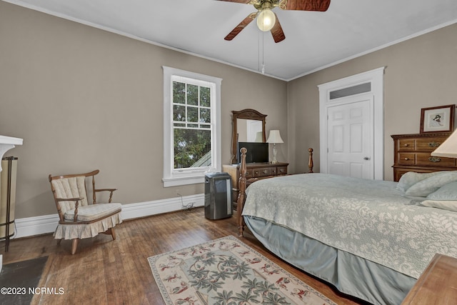 bedroom featuring a ceiling fan, crown molding, baseboards, and wood finished floors