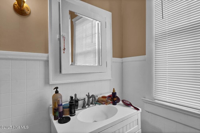 bathroom featuring vanity and tile walls