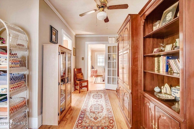 interior space featuring ceiling fan, light hardwood / wood-style floors, ornamental molding, and french doors