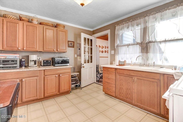 kitchen featuring a textured ceiling, range, sink, and ornamental molding