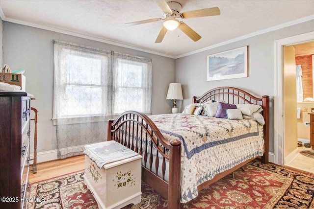 bedroom featuring ceiling fan, light hardwood / wood-style floors, ornamental molding, and ensuite bath