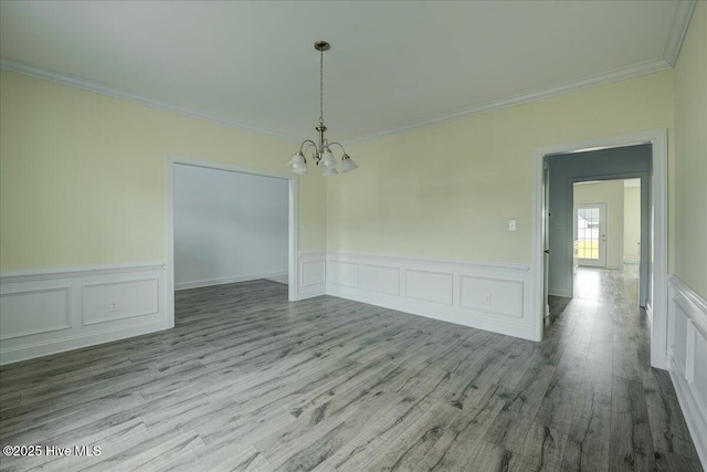 2022 Tarpon Trl, New Bern, NC 28562 - unfurnished dining area featuring a chandelier, crown molding, wood finished floors, a decorative wall, and a wainscoted wall