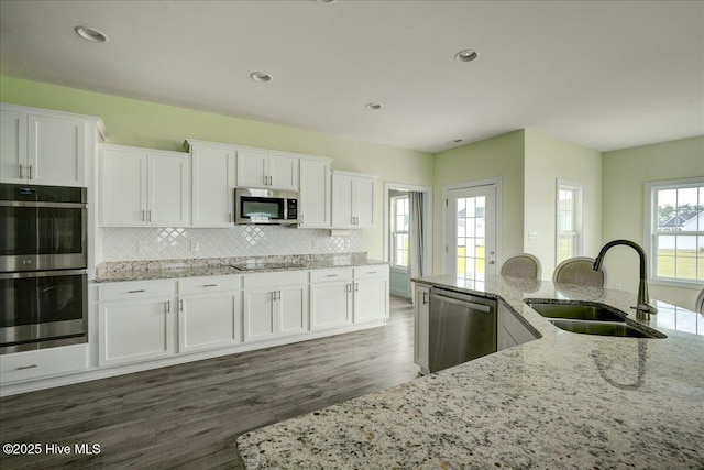 2022 Tarpon Trl, New Bern, NC 28562 - kitchen featuring stainless steel appliances, a sink, white cabinets, backsplash, and recessed lighting