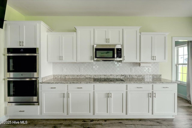 2022 Tarpon Trl, New Bern, NC 28562 - kitchen featuring stainless steel appliances, white cabinetry, and backsplash