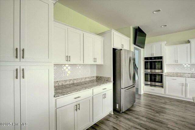 2022 Tarpon Trl, New Bern, NC 28562 - kitchen with appliances with stainless steel finishes, tasteful backsplash, white cabinets, dark wood-type flooring, and light stone countertops