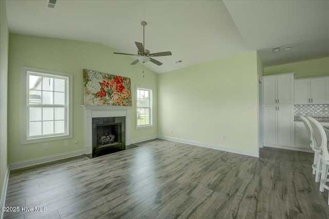 2022 Tarpon Trl, New Bern, NC 28562 - unfurnished living room with vaulted ceiling, ceiling fan, wood finished floors, a tile fireplace, and baseboards