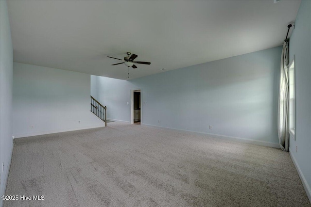 2022 Tarpon Trl, New Bern, NC 28562 - unfurnished living room featuring ceiling fan, carpet floors, baseboards, and stairs