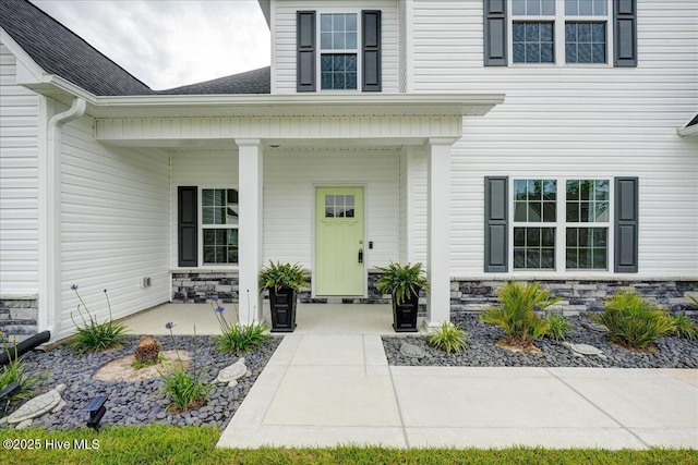 2022 Tarpon Trl, New Bern, NC 28562 - doorway to property featuring covered porch, stone siding, and roof with shingles