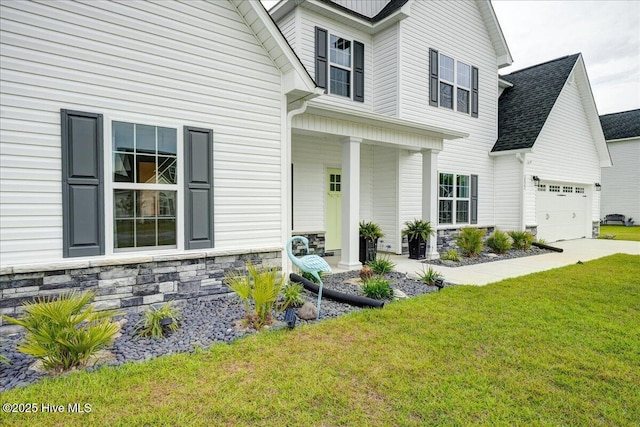 2022 Tarpon Trl, New Bern, NC 28562 - view of front of home with stone siding, a garage, a front yard, and a porch