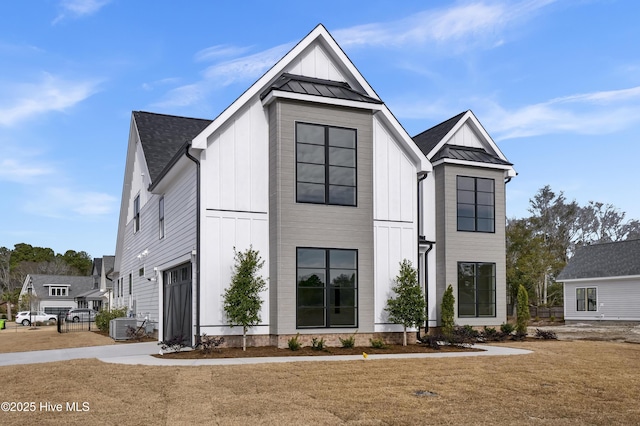 modern inspired farmhouse with central air condition unit and a front lawn