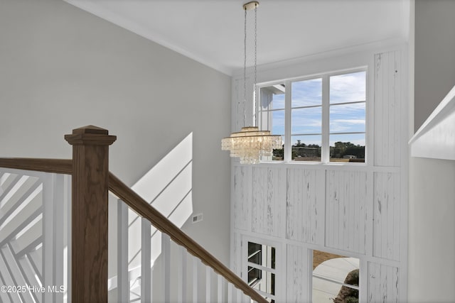 staircase with a notable chandelier