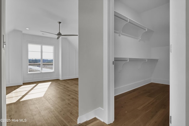 spacious closet with dark hardwood / wood-style floors, ceiling fan, and lofted ceiling