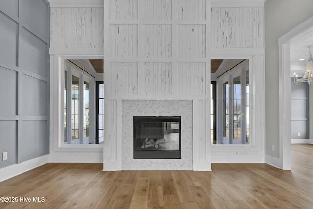 unfurnished living room featuring hardwood / wood-style flooring and a chandelier