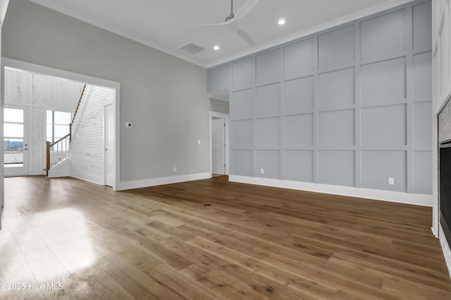 unfurnished living room with ceiling fan, ornamental molding, and hardwood / wood-style flooring