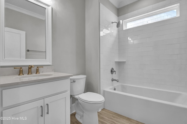 full bathroom featuring vanity, bathtub / shower combination, hardwood / wood-style flooring, toilet, and ornamental molding