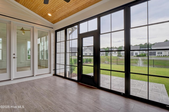 unfurnished sunroom with lofted ceiling, ceiling fan, plenty of natural light, and wooden ceiling