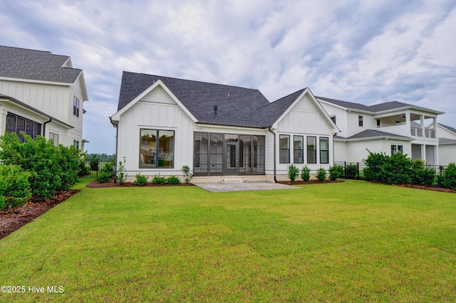 back of house featuring a sunroom, a patio area, and a yard