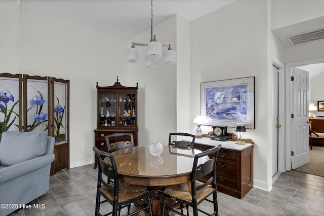 dining space with a notable chandelier and lofted ceiling