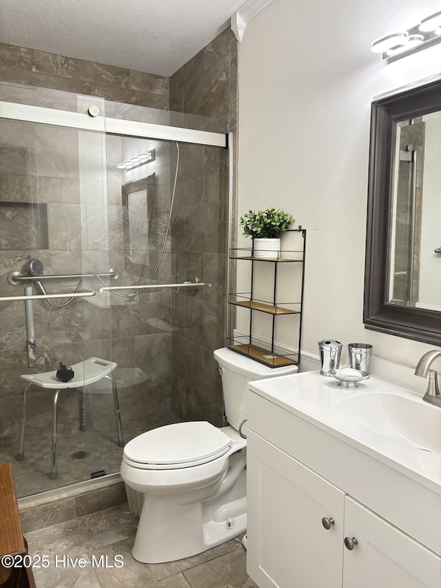 bathroom with a textured ceiling, vanity, toilet, and walk in shower