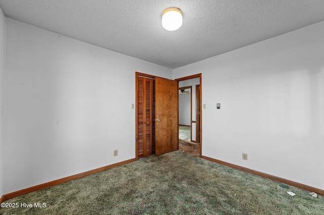 carpeted empty room featuring a textured ceiling