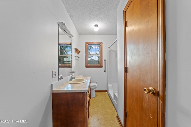 bathroom with toilet, vanity, a textured ceiling, and walk in shower