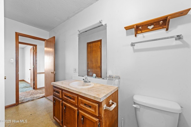 bathroom featuring vanity, a textured ceiling, and toilet