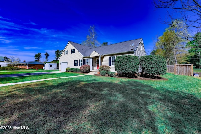 view of front of property featuring an outbuilding, a front yard, and a garage