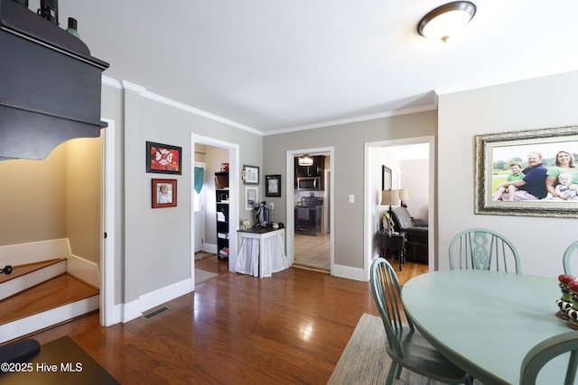 dining room featuring dark hardwood / wood-style floors and ornamental molding