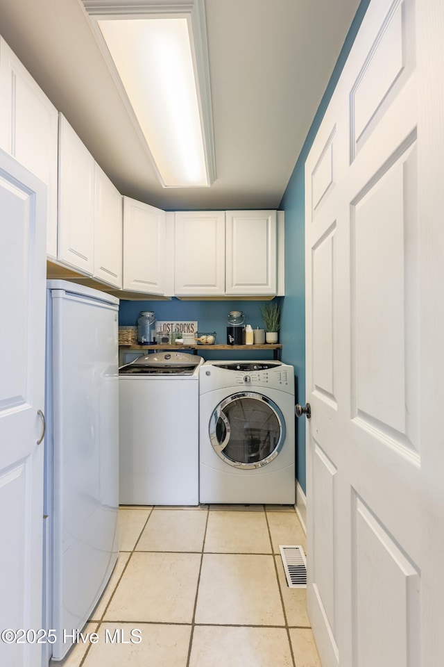 washroom with light tile patterned floors, cabinets, and independent washer and dryer