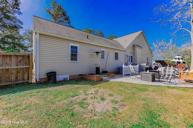 back of house with a patio area and a yard