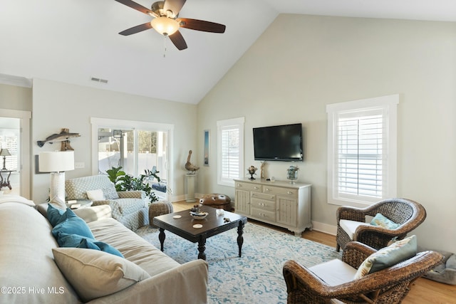 living room featuring hardwood / wood-style floors, plenty of natural light, ceiling fan, and high vaulted ceiling