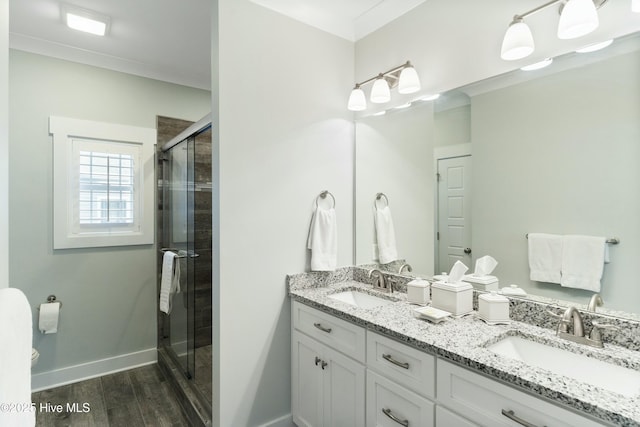 bathroom featuring vanity, wood-type flooring, an enclosed shower, and ornamental molding