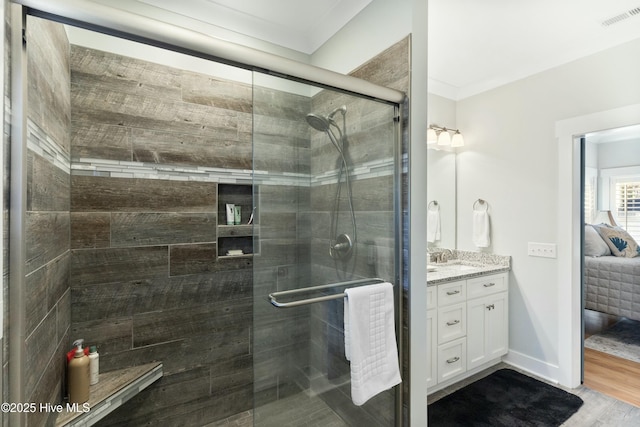 bathroom with vanity, hardwood / wood-style flooring, an enclosed shower, and ornamental molding